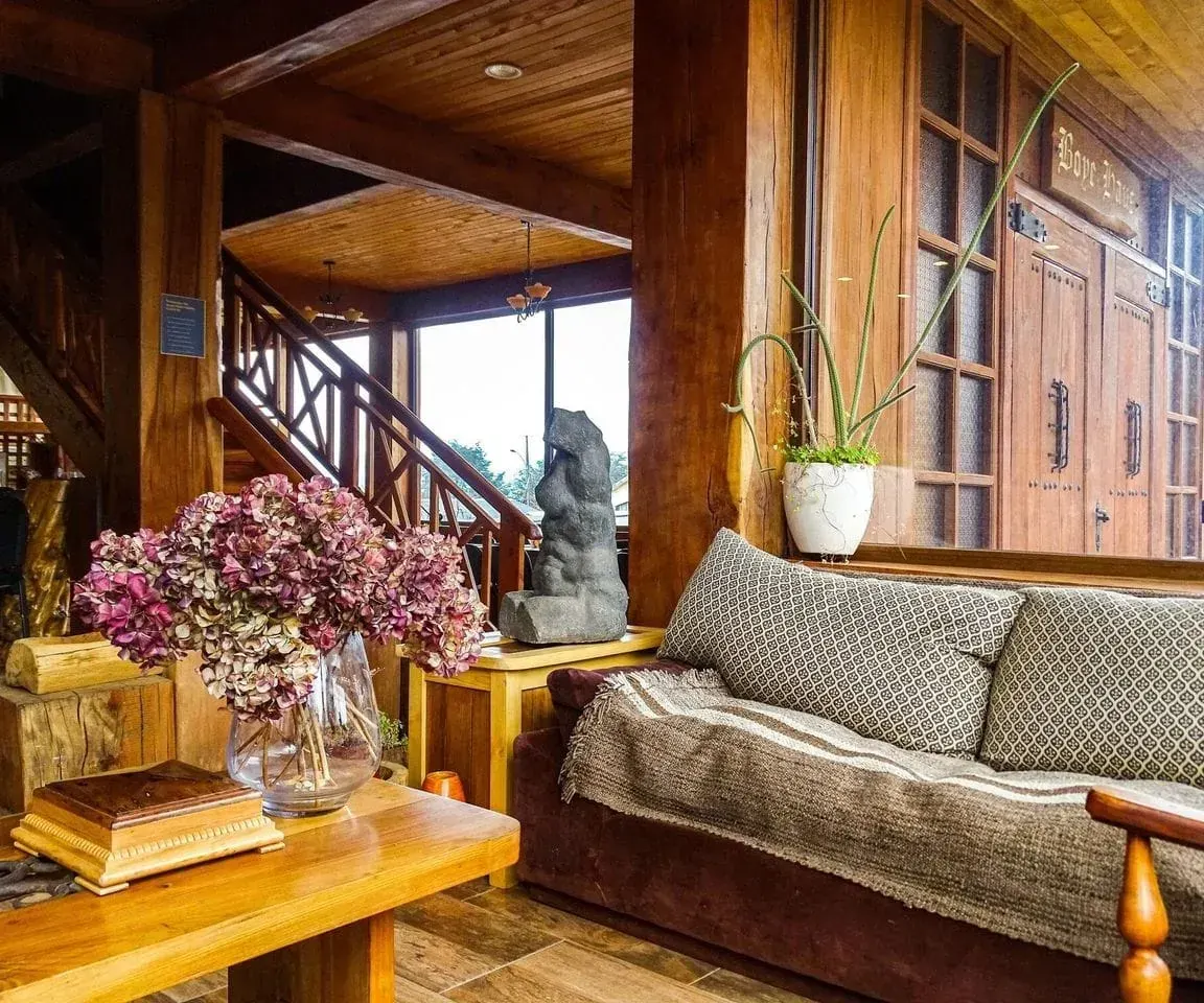Salón principal de La Casona de Futrono con madera nativa y escalera artesanal